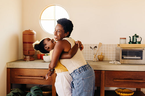 Young girl having fun with her mom in the kitchen