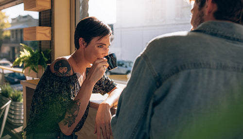 Woman drinking coffee her friend