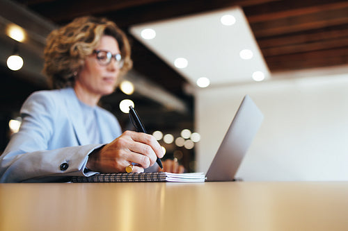 Professional designer creating a to do list on a notepad at work