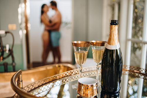 Alcoholic beverages placed on a table with a couple in the backg