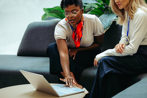 African businesswoman demonstrating ideas on laptop in office setting