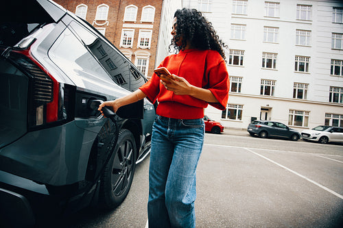 Commuting by car feels future-focused as a woman charges in a parking area