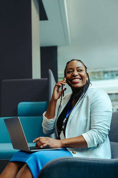 Successful African businesswoman multitasking at work with a smile