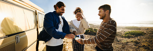 Friends decide their next move on a scenic coastal road trip at sunset