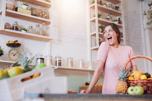 Excited young woman working at juice bar