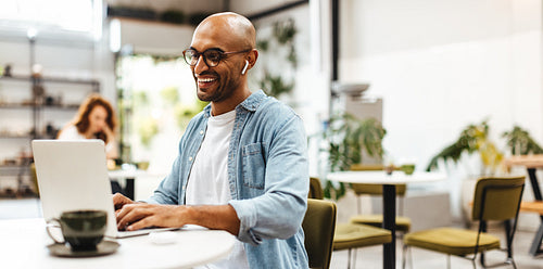 Successful business man working remotely at a cafe