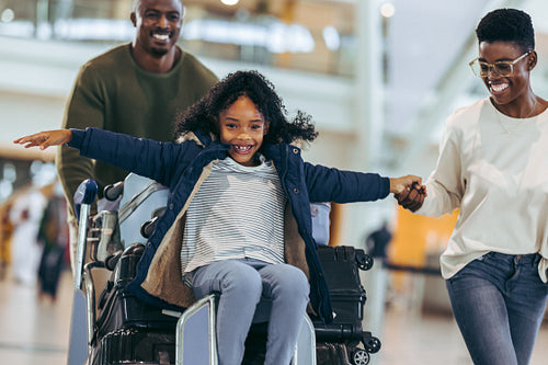 African family of three having fun at airport