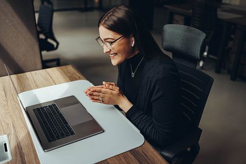 Smiling businesswoman attending a virtual meeting in an office