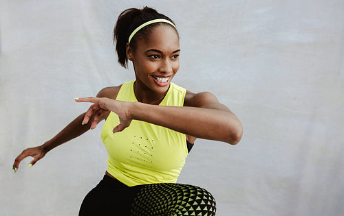 Confident sportswoman doing stretching exercises