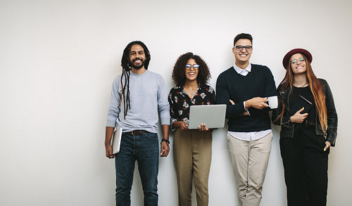 Businessman holding a coffee cup standing with coworkers in office
