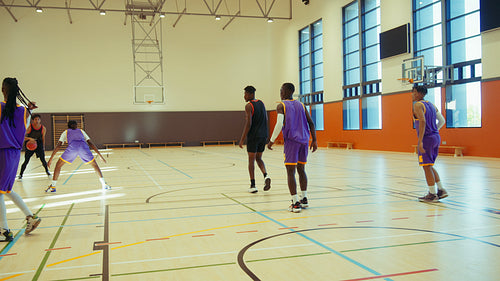 Young men playing basketball in gym