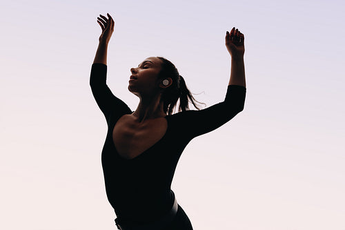 Graceful dance moves: Expressive female dances to music with wireless earphones