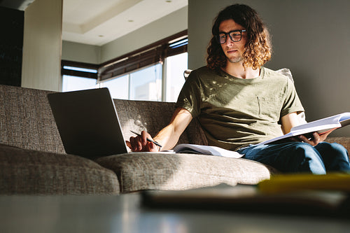 Student sitting on couch and studying