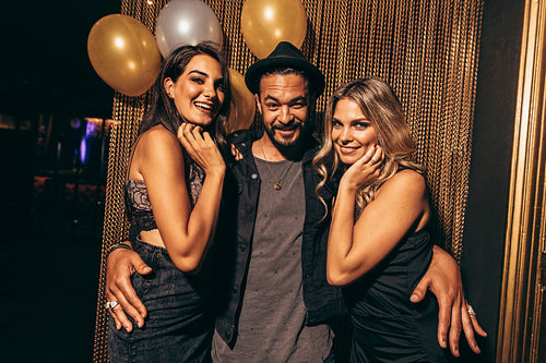 Handsome young man with female friends at nightclub