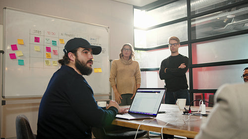 Scrum master having a meeting with her team in a tech company