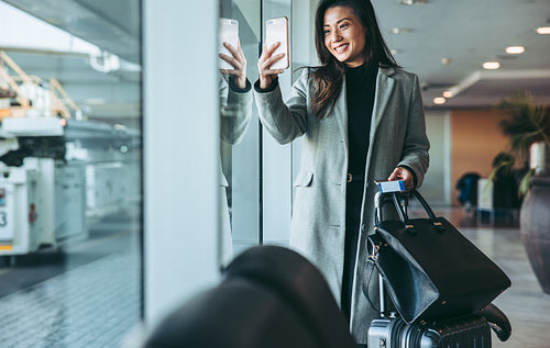 Woman traveler taking selfie at airport waiting lounge