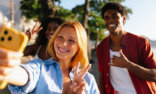 Friends enjoying a summer day taking a selfie together outdoors