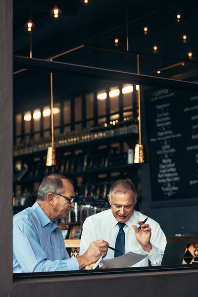 Two senior men having business meeting in a pub