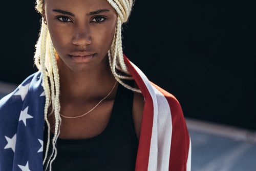 Female athlete with american flag on her back