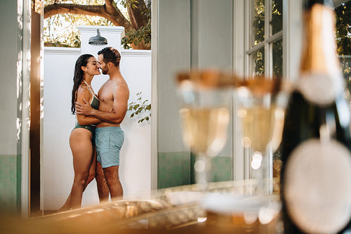 Smiling couple showering together outside their hotel room