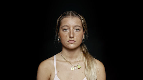 Woman with blank expression on black background