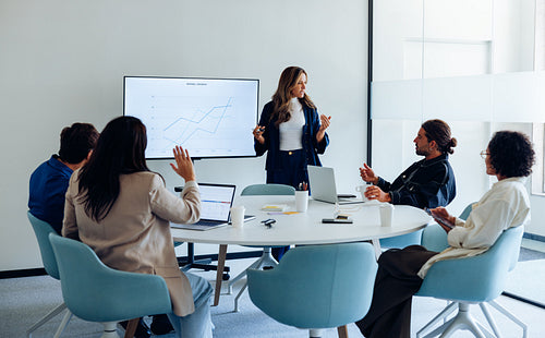Presenter leads team meeting with chart analysis