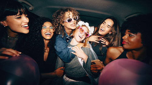 Group of young women celebrating and having fun in the back of a cab