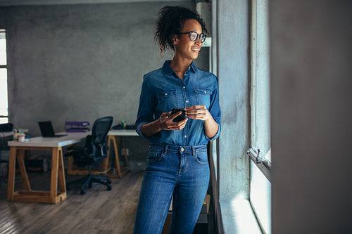 Woman looking out of a window in office