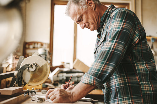 Senior carpenter planning his work at carpentry