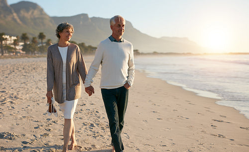 Senior relaxed couple walking on beach