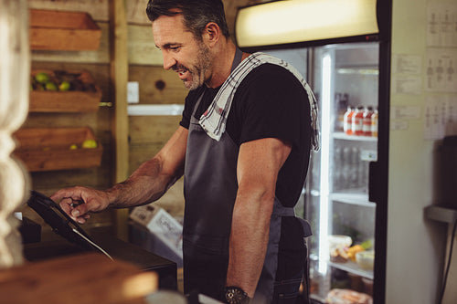 Barista checking client's order on cashbox computer