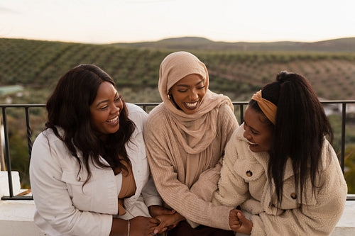 Young ethnic friends laughing together outdoors