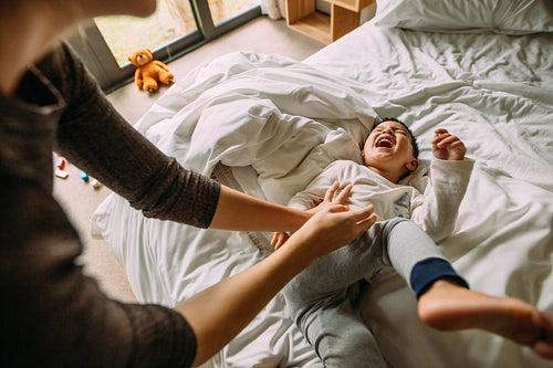 Mother and son playing together on bed