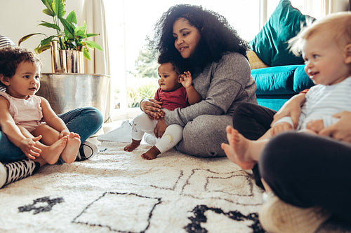 Mothers group with their children at home