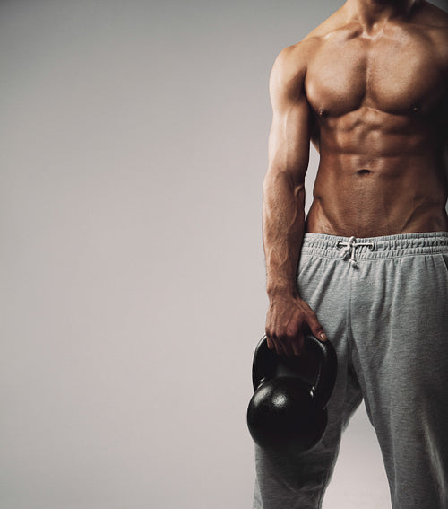 Muscular young guy with kettle bell