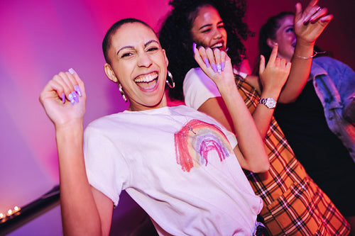 Young woman dancing with her friends at a party