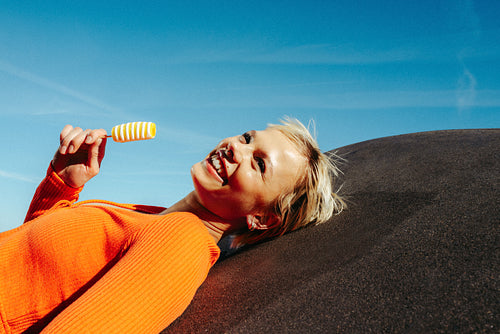 Woman enjoys popsicle on sunny day outdoors