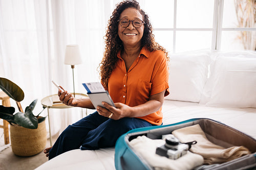 Planning retirement travel: Mature woman packing for a vacation