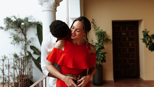 Romantic young man kissing his girlfriend on a balcony