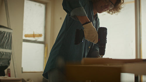 Confident and capable: Woman drilling wood during a home renovation project