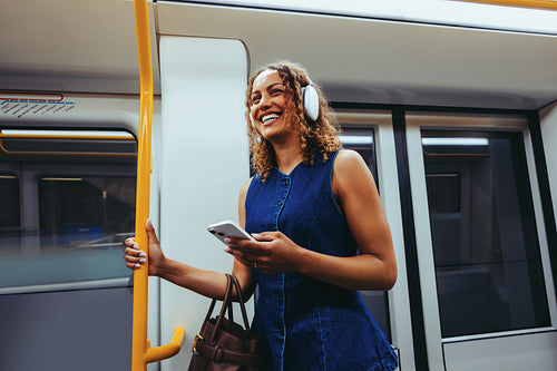 Happy woman uses smartphone on the train during her commute