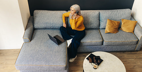 Mature woman calling her work colleagues from the comfort of her home