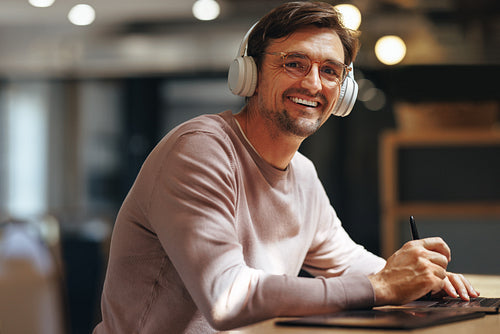 Happy graphic designer working on a project in a cafe