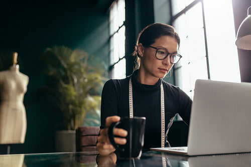 Female dress designer using laptop