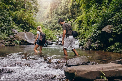 Couple walking across the stream.
