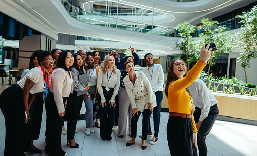Diverse team taking a group selfie during an office tour