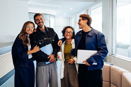 Four professionals smile together in office