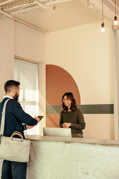 Businessman signing in to an office at the front desk