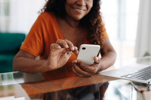 Cheerful senior woman using a mobile app on her smartphone