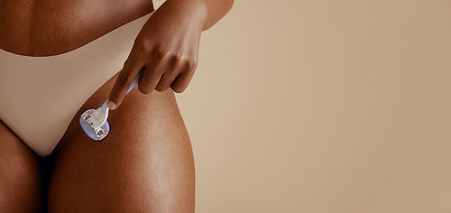 Confident woman practicing self-care and empowerment with shaving stick for personal hygiene